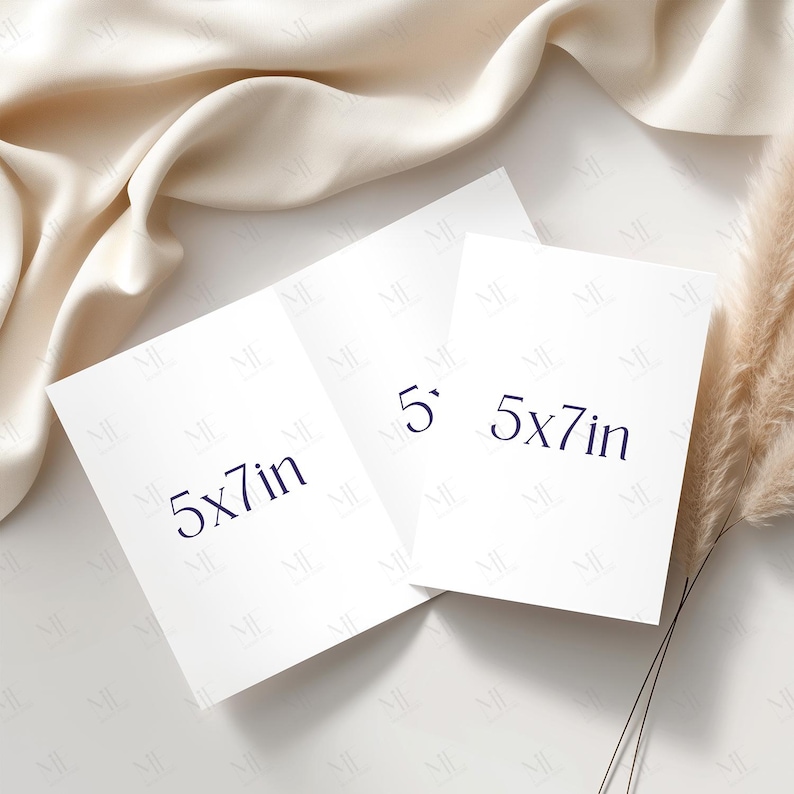 May include: Three white 5x7 inch cards with dark blue text, arranged on a white surface with a cream-colored fabric and dried plant accents. The cards are rectangular and the text indicates their dimensions.