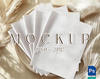 Puede incluir: Una pila de hojas de papel blancas dispuestas sobre una bandeja de madera, con la palabra "MOCKUP" en letras grandes. La imagen incluye el texto "PSD + JPG" y los iconos de Photoshop y Procreate. El fondo presenta tonos suaves y neutros.