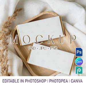 May include: Two white rectangular mockups with gold trim are displayed on a wooden tray. The word "MOCKUP" is printed in a brown font. The text "PSD + JPG + PNG" is also visible. The image also includes the text "EDITABLE IN PHOTOSHOP | PHOTOPEA | CANVA".