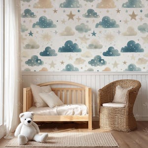May include: A nursery scene featuring a wooden crib, a wicker chair, and a large white teddy bear. The wall is decorated with a whimsical cloud and star pattern in shades of blue, beige, and white. A neutral-toned rug sits on the floor.
