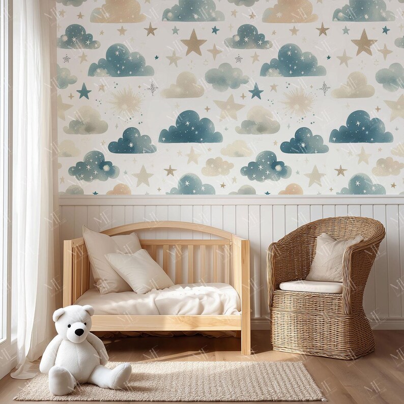 May include: A nursery scene featuring a wooden crib, a wicker chair, and a large white teddy bear. The wall is decorated with a whimsical cloud and star pattern in shades of blue, beige, and white. A neutral-toned rug sits on the floor.