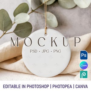 May include: A white, circular ceramic ornament mockup with the word "MOCKUP" in dark letters. The text "PSD + JPG + PNG" is below the word "MOCKUP". The ornament hangs from a gold string. The bottom of the image reads "EDITABLE IN PHOTOSHOP | PHOTOPEA | CANVA".