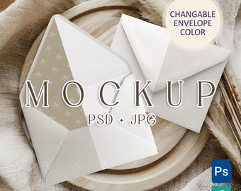 Op de afbeelding: Een mockup van een witte envelop met een bruine, gepatenteerde envelop erin. De enveloppen liggen op een houten dienblad met een beige stoffen achtergrond. De tekst "MOCKUP" en "PSD + JPG" staat op de enveloppen gedrukt. De tekst "CHANGEABLE ENVELOPE COLOR" staat op een witte cirkel gedrukt.