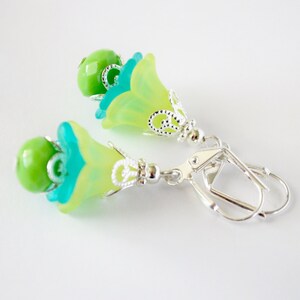May include: A pair of green and blue flower-shaped earrings with silver accents and leverback closures.