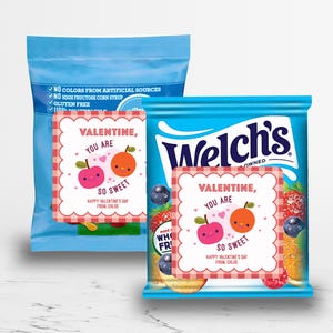 May include: Two blue Welch's fruit snack bags with Valentine's Day cards. The cards read "Valentine, you are so sweet" with cartoon fruit illustrations. The bags have text indicating they are gluten-free and contain no artificial colors or high fructose corn syrup.