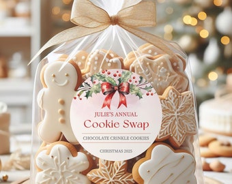 May include: A clear plastic bag filled with decorated Christmas cookies. The bag has a gold ribbon tied around it and a round sticker with a watercolor design of a red bow and holly. The sticker says "Julie's Annual Cookie Swap, Chocolate Crinkle Cookies, Christmas 2025."