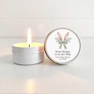 May include: A white candle in a tin with a bunny ear design on the lid. The lid has the text "Some Bunny is on the Way" with the date "4.12.2025" and the words "Anna's Baby Shower".