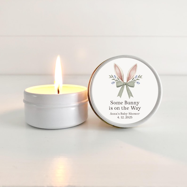 May include: A white candle in a tin with a bunny ear design on the lid. The lid has the text "Some Bunny is on the Way" with the date "4.12.2025" and the words "Anna's Baby Shower".