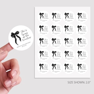 May include: A sheet of 2-inch round stickers with a black and white design. The stickers feature a black bow with a white outline and the text "She's tying up her twenties". The text "Ashley's 30th Birthday 05.24.25" is also included on the stickers.