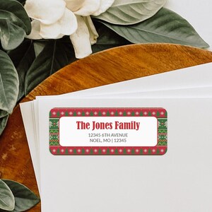 May include: Red and green Christmas address label with a white border and a festive knit pattern. The label reads "The Jones Family", "12345 6th Avenue", "Noel, MO | 12345".