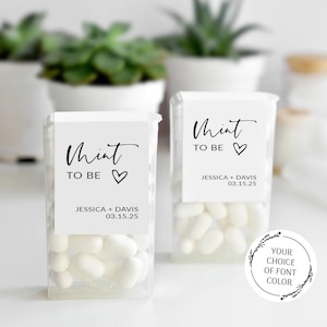 May include: Two clear plastic containers filled with white mints. Each container has a white label with the words "Mint to Be" and a heart symbol, along with the names Jessica and Davis and the date 03.15.25. A circular graphic is also visible.