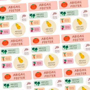May include: A repeating pattern of name labels with the name "ABIGAIL FOSTER". The labels feature illustrations of vegetables including tomatoes, broccoli, carrots, and squash. The labels are in various shapes and colours.