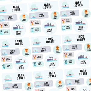 May include: A collection of white and light blue labels with the name "JACK JONES" printed on them. The labels feature swimming-themed illustrations, including a swimmer, a life vest, a medal, goggles, and a pool.