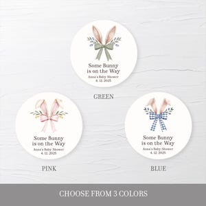 May include: Three round stickers with a bunny rabbit illustration and the text "Some Bunny is on the Way" with a choice of green, pink, or blue bows. The text also includes "Anna's Baby Shower" and the date "4. 12. 2025".