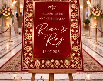 May include: A red and gold welcome sign on a wooden easel. The sign reads "Welcome to the Anand Karaj of Rina & Raj 16.07.2026." A floral arrangement of red and white roses sits at the base of the easel, with candles and rose petals.