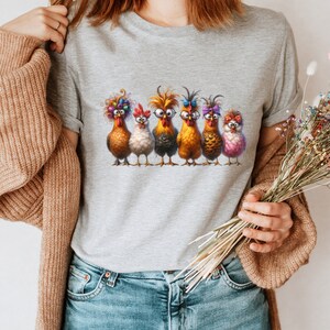 May include: A gray t-shirt with a graphic of six chickens wearing glasses and various accessories. The chickens are standing in a row and looking at the viewer.