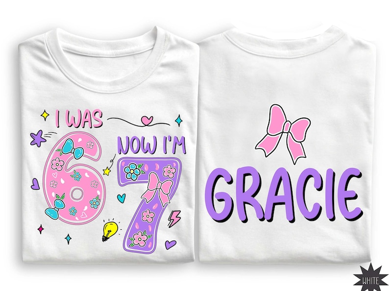 May include: Two white t-shirts featuring colorful graphic designs. The left shirt displays the text I WAS NOW I'M with a pink number 6 and a purple number 7 decorated with flowers, bows, and stars. The right shirt features a pink bow and the name GRACIE in large purple letters.