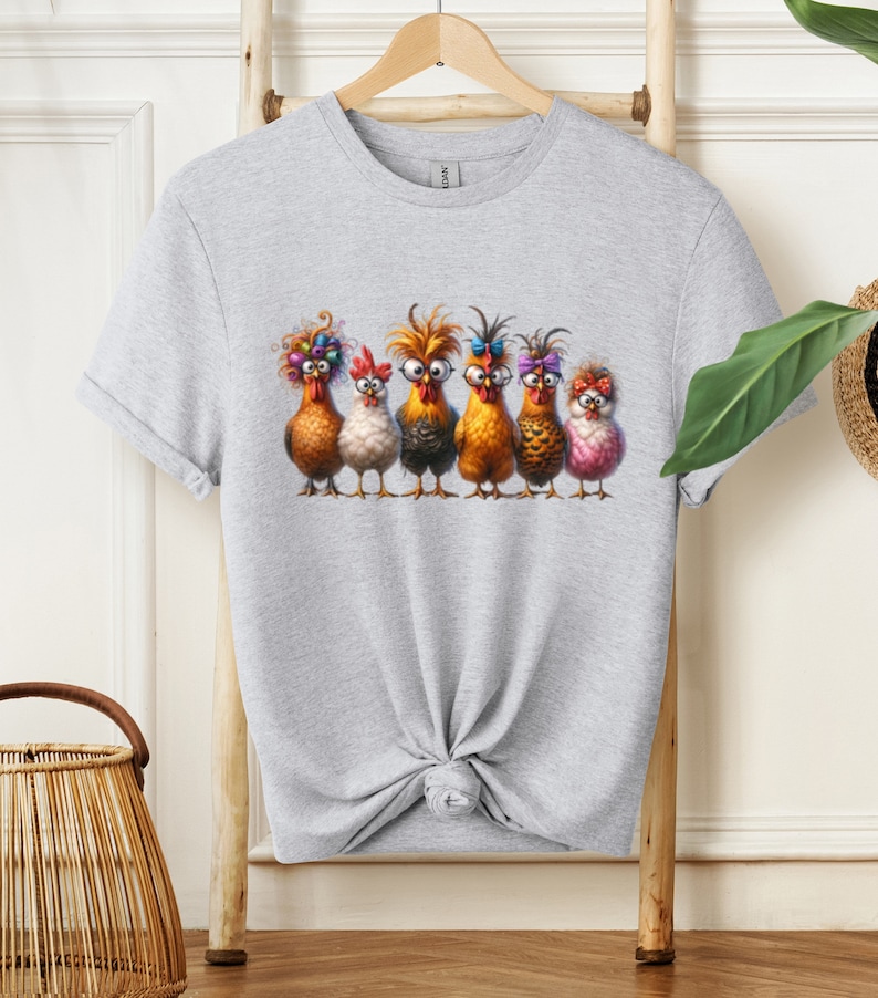 May include: A gray t-shirt with a graphic of six chickens wearing colorful accessories. The chickens are lined up in a row and have different expressions on their faces.