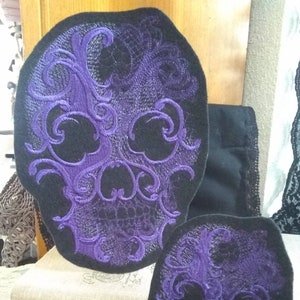 May include: Two purple embroidered skull patches with intricate designs. The larger patch is about 6 inches in diameter and the smaller patch is about 4 inches in diameter.