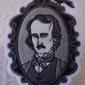 May include: Embroidered patch featuring a portrait of Edgar Allan Poe in a black and white oval frame with a raven perched on top. The patch is on a white background.