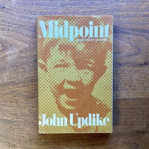 May include: A book cover with a yellow and brown background. The title "Midpoint and other poems" is printed in white. The author's name "John Updike" is printed in white below the title.