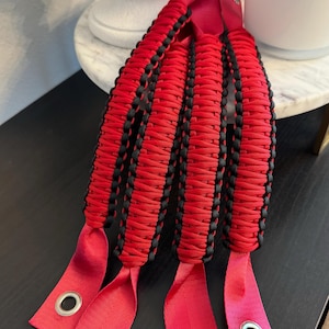May include: Four red and black paracord handles with metal grommets. The handles are braided with red and black paracord.