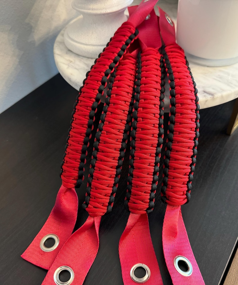 May include: Four red and black paracord handles with metal grommets. The handles are braided with red and black paracord.