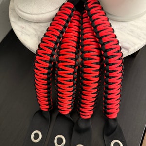 May include: Four red and black paracord Jeep grab handles with black webbing loops and metal eyelets.