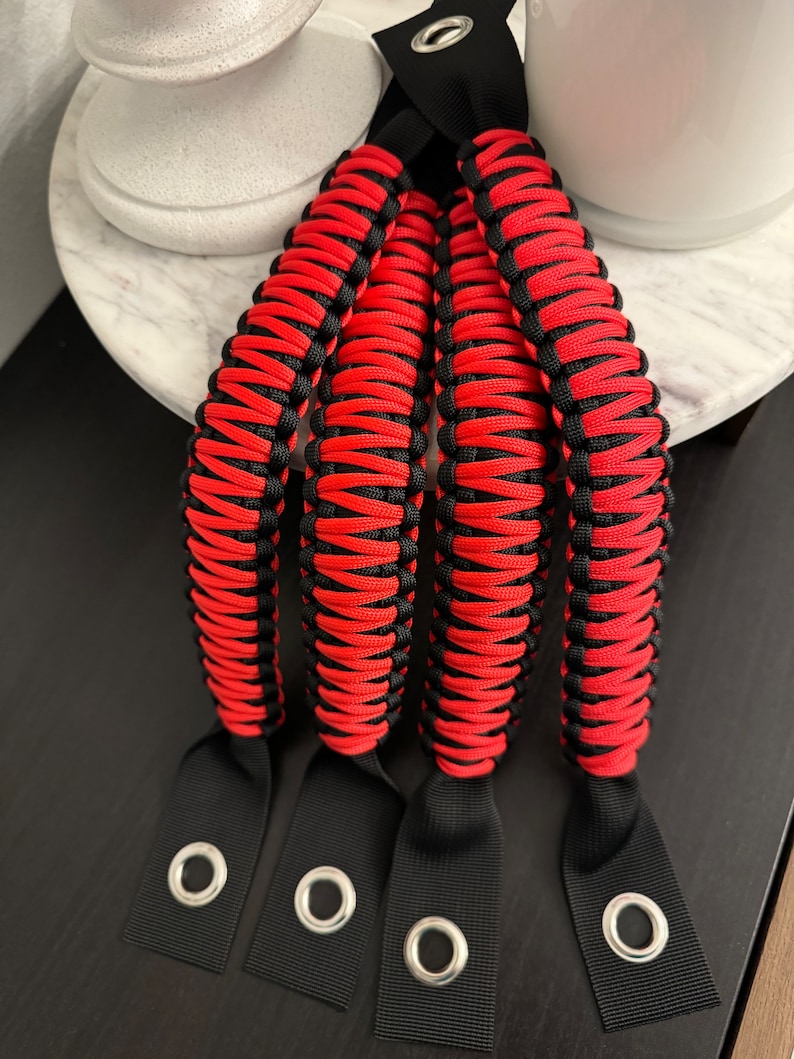 May include: Four red and black paracord Jeep grab handles with black webbing loops and metal eyelets.
