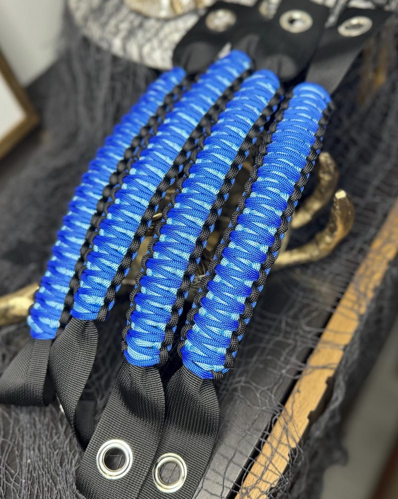 May include: Set of four blue and black paracord jeep door handles. The handles are made with a braided paracord and have black straps with metal rings.