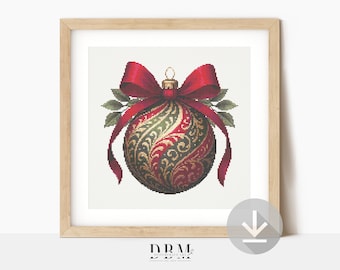 May include: A framed print of a Christmas ornament. The ornament is a detailed cross-stitch design in red, green, and gold, with a red bow and green leaves. The frame is light wood.