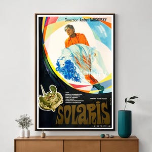 Könnte beinhalten: Ein Vintage-Filmplakat für den Film Solaris, Regie Andrei Tarkowski. Das Plakat zeigt ein farbenfrohes abstraktes Design mit einem Mann und einer Frau im Zentrum. Der Titel "Solaris" ist in einer fetten, stilisierten Schrift geschrieben.