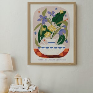 May include: A framed illustration of a white ceramic vase with a blue rim filled with purple violets and yellow primroses. The vase is sitting on a red and orange checkered surface. The text "FEBRUARY - VIOLET & PRIMROSE" is at the bottom of the illustration.