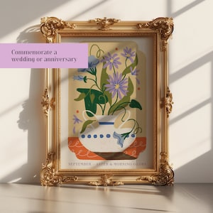 Op de afbeelding: Een ingelijste illustratie van een vaas met paarse asters en blauwe ochtendglorie bloemen. De vaas is wit met blauwe en witte stippen. De achtergrond is lichtgeel met oranje en rode accenten. De tekst onderaan luidt "SEPTEMBER - ASTER & MORNING GLORY".