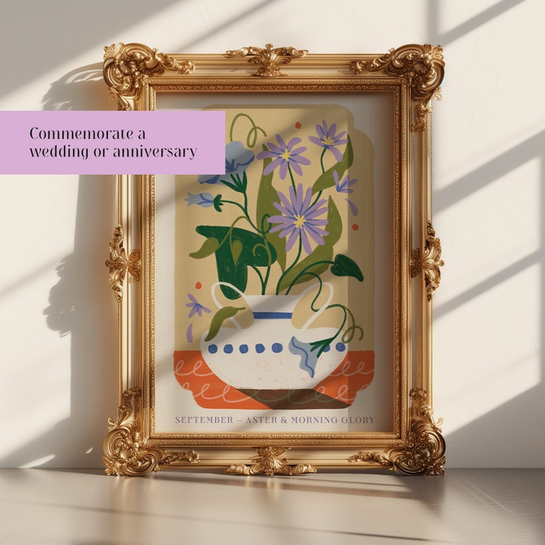 Op de afbeelding: Een ingelijste illustratie van een vaas met paarse asters en blauwe ochtendglorie bloemen. De vaas is wit met blauwe en witte stippen. De achtergrond is lichtgeel met oranje en rode accenten. De tekst onderaan luidt "SEPTEMBER - ASTER & MORNING GLORY".