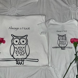 May include: Two white t-shirts with an owl graphic and the text "Always a Hoot". The larger shirt has a larger owl graphic.