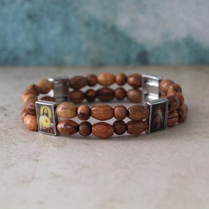 Sie erhalten zwei handgefertigte Perlenarmbänder aus Olivenholz, bunte Ikonen der Mutter Maria und des Segens Jesus, hergestellt im Heiligen Land Jerusalem
