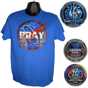 Könnte beinhalten: Ein blaues T-Shirt mit einem NASA-inspirierten Design und dem Wort "PRAY" in Weiß. Das Design umfasst einen roten Swoosh und einen kreisförmigen Hintergrund mit Sternen. Das Shirt ist ein Gildan Adult Heavy T-Shirt.
