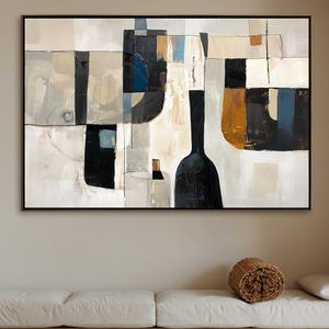 May include: Abstract art piece in a black frame. The artwork features a geometric design with shapes in black, white, beige, and blue. The painting hangs above a white sofa and a wooden coffee table.