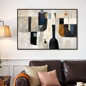 May include: Abstract art print featuring a black framed canvas with a geometric design. The artwork uses a palette of black, white, beige, and blue. The composition includes shapes resembling bottles and rectangular blocks. The painting hangs above a brown leather sofa.