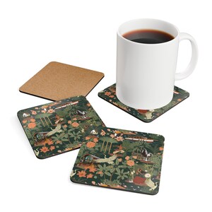 May include: A white ceramic mug and three square coasters with rounded corners. The coasters feature a dark green background with a repeating pattern of orange flowers, white cranes, tropical foliage, small boats, and figures in a landscape.