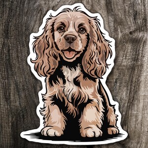 May include: A sticker featuring a cartoon illustration of a Cocker Spaniel dog. The dog has brown and tan fur, with a happy expression and its tongue sticking out. The sticker has a white border and is set against a wood grain background.