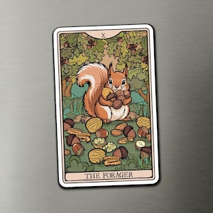 May include: A rectangular magnet featuring a tarot-style illustration of a brown squirrel holding a cluster of nuts. The background shows green oak leaves and acorns. The top has the Roman numeral X and the bottom reads THE FORAGER in black text.