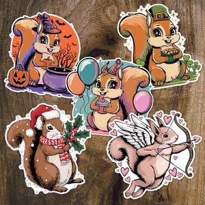 May include: Set of five cartoon squirrel stickers. One squirrel wears a witch hat and holds a pumpkin, another wears a St. Patrick's Day hat, and a third wears a Santa hat. Other stickers show squirrels with balloons and wings.