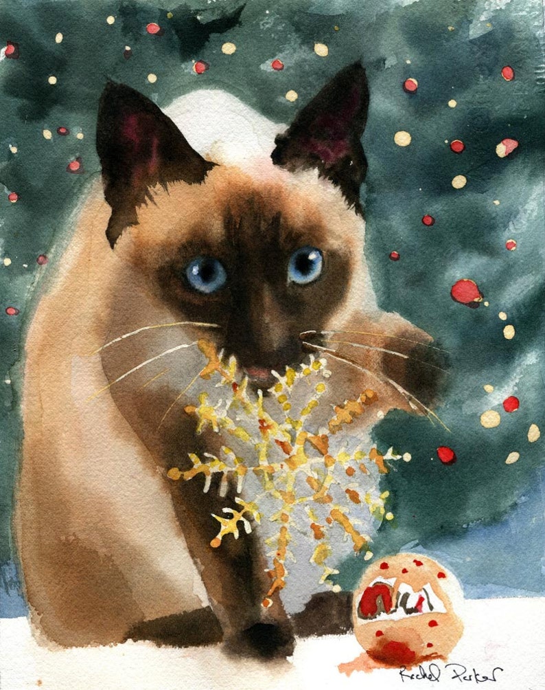 May include: Watercolor painting of a Siamese cat with blue eyes, holding a gold snowflake ornament in its mouth. The cat is set against a dark green background with red and yellow bokeh, and a small ornament on the ground.