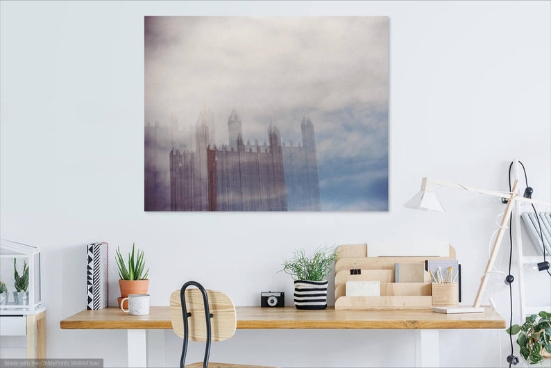 May include: A photograph of a tall building with a cloudy sky in the background. The building is tall and narrow, with many windows. The sky is a light blue color, with white clouds.