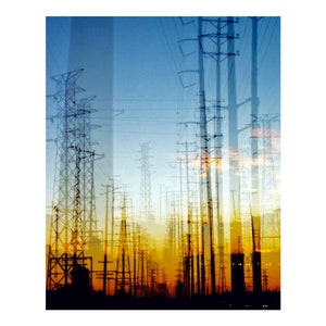 May include: A double exposure photograph of a field of power lines against a blue sky with a yellow and orange sunset in the background.
