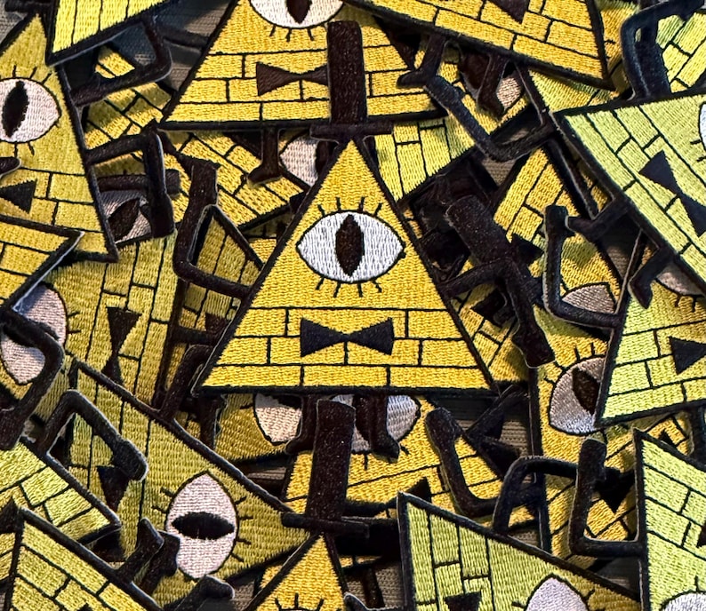 Peut inclure: Un ensemble de patchs triangulaires jaunes avec un &oelig;il unique, un n&oelig;ud papillon et un motif de briques. Les patchs ont des d&eacute;tails noirs et blancs et sont brod&eacute;s. Les patchs sont probablement destin&eacute;s aux v&ecirc;tements ou aux accessoires.
