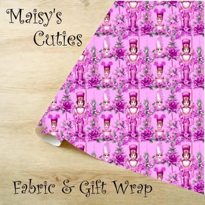Op de afbeelding: Roze stof en cadeaupapier met een herhalend patroon van speelgoedsoldaten, rozen en bloemelementen. De woorden "Maisy's Cuties" en "Fabric & Gift Wrap" zijn op de stof gedrukt.