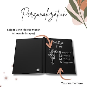 May include: A black journal featuring the text God Says I am and the name EMMA with corresponding words Equipped, Merciful, Marked, and Accepted. A white line drawing of a flower is displayed next to the name. The text Personalization is at the top.